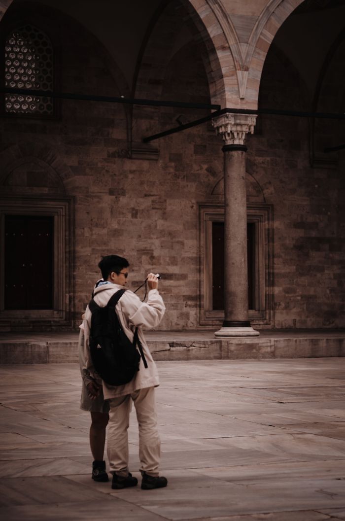 Tourists capturing a moment within a historic arched building interior.